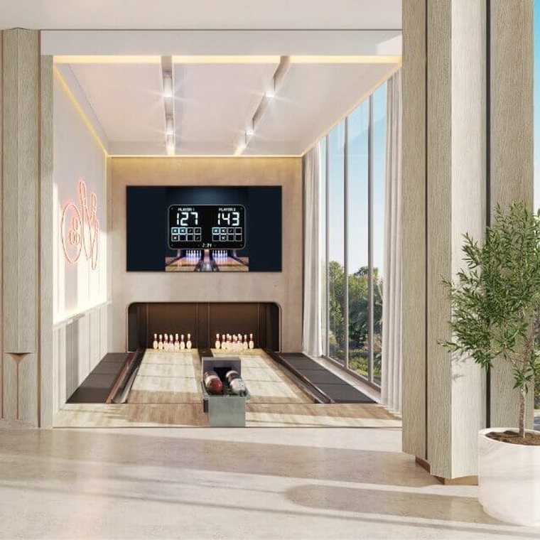 Private bowling alley at Ellington Villas Dubai — two lanes with a lit scoreboard and fluted timber walls